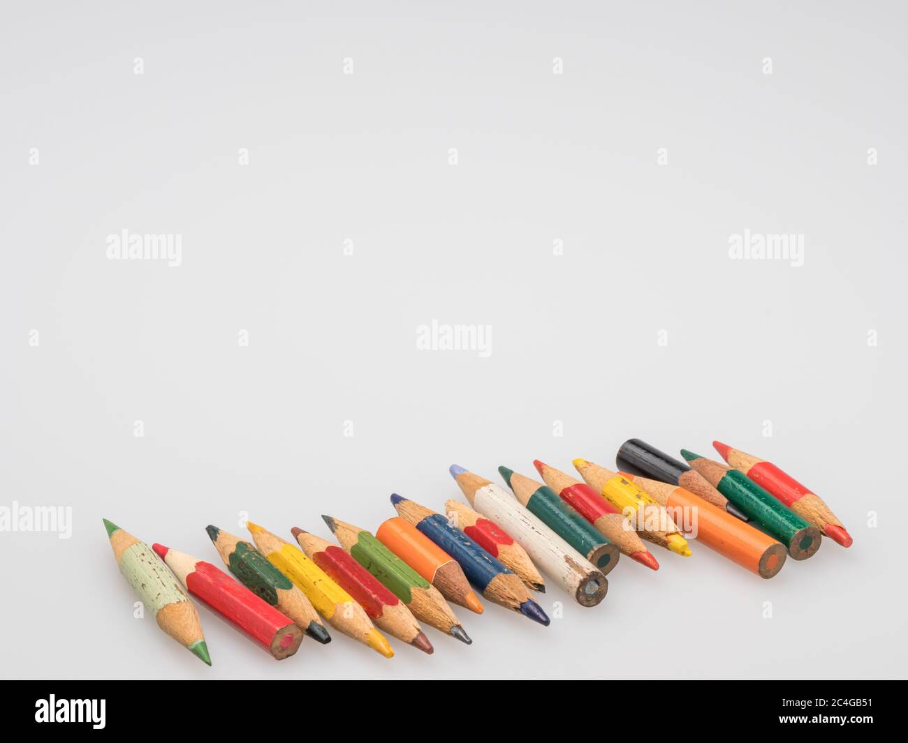 The remains of old colored pencils. Little pencils on a white background. Stock Photo