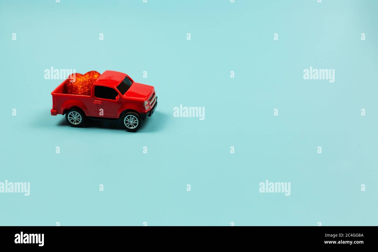 Valentines Day Concept. Miniature red toy car with red heart Stock Photo