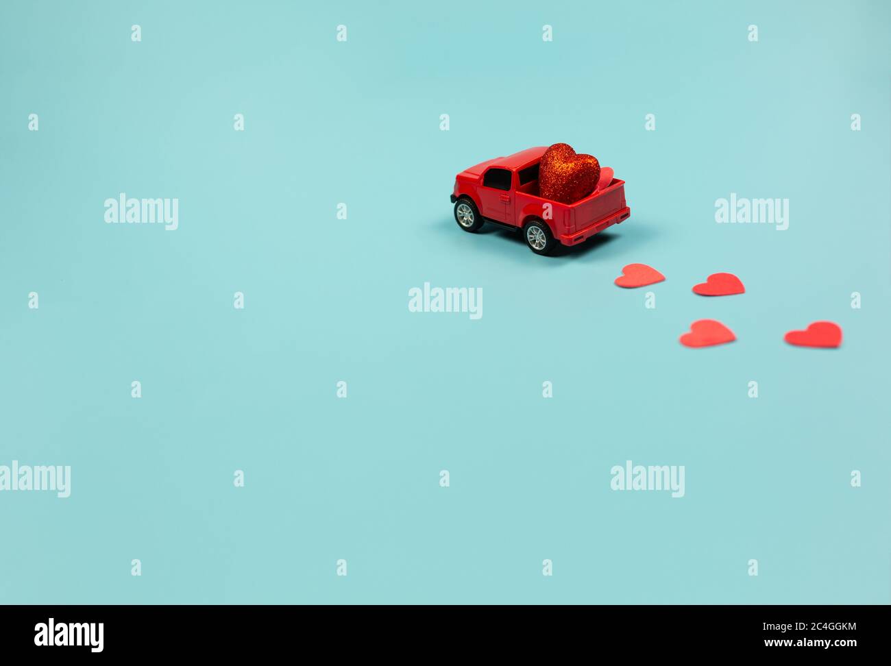 Valentines Day Concept. Miniature red toy car with red hearts Stock Photo