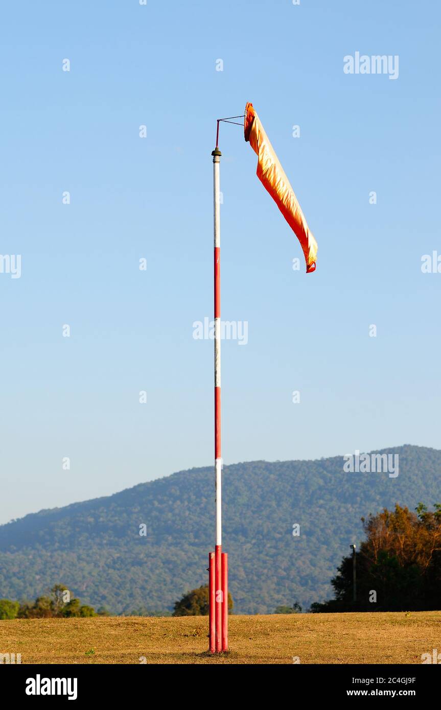 An Orange Windsock or Windvane on a Red and White Pole Stock Photo