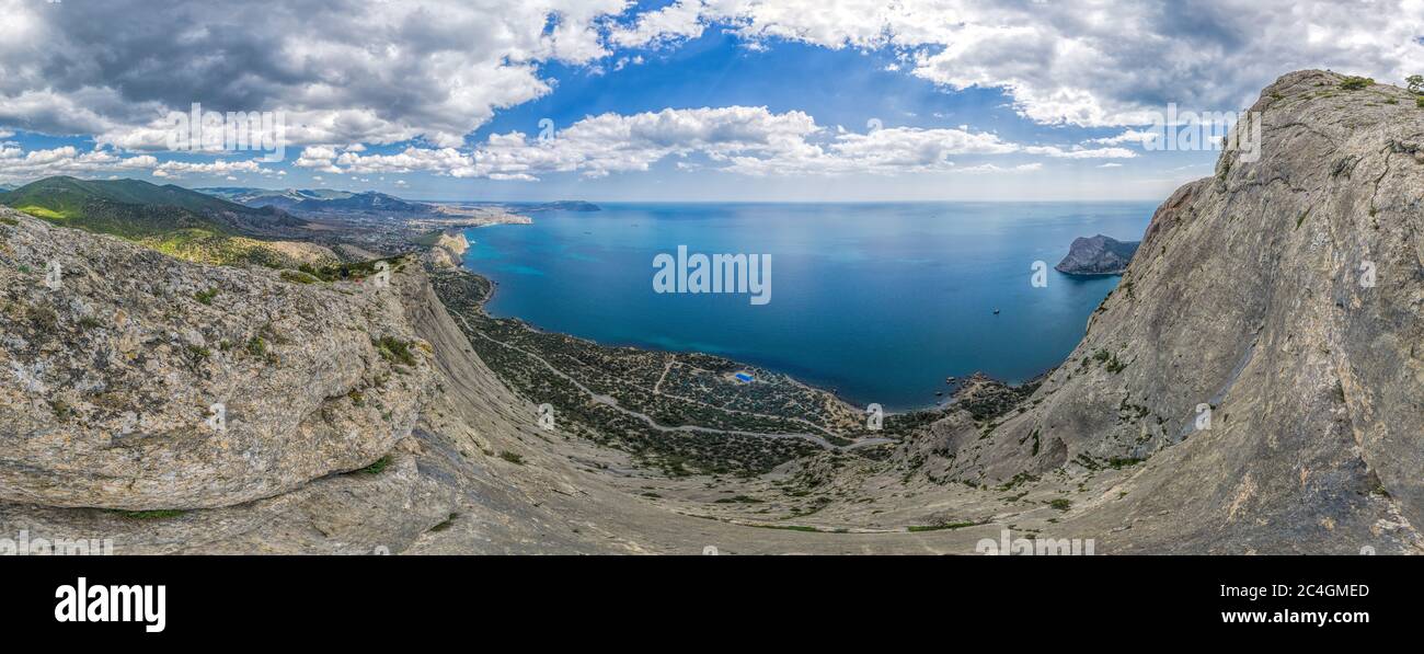Scenic high angle view towards Sudak resort town, Fortress from the top of Falcon Mountain, ecological trail Alchak-Kaya in Crimea. The concept of an Stock Photo