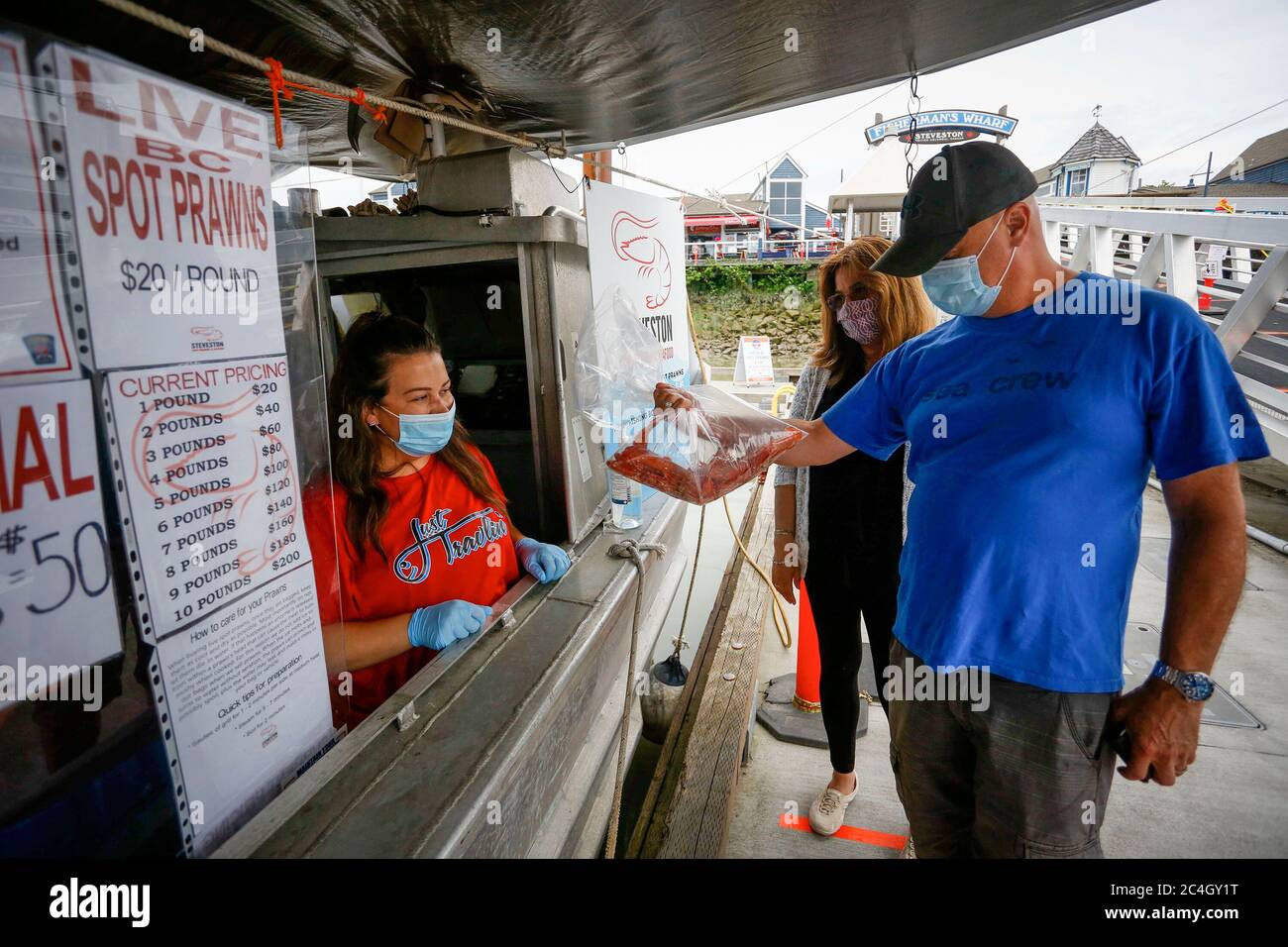 Richmond, Canada. 26th June, 2020. People wear face masks as they shop for seafood at Steveston Fisherman's Wharf, a popular tourist spot in Richmond, British Columbia, Canada, June 26, 2020. Steveston Fisherman's Wharf has adopted stricter safety measures starting from Friday that visitors entering its premises must wear a face mask to reduce the spread of COVID-19. Credit: Liang Sen/Xinhua/Alamy Live News Stock Photo