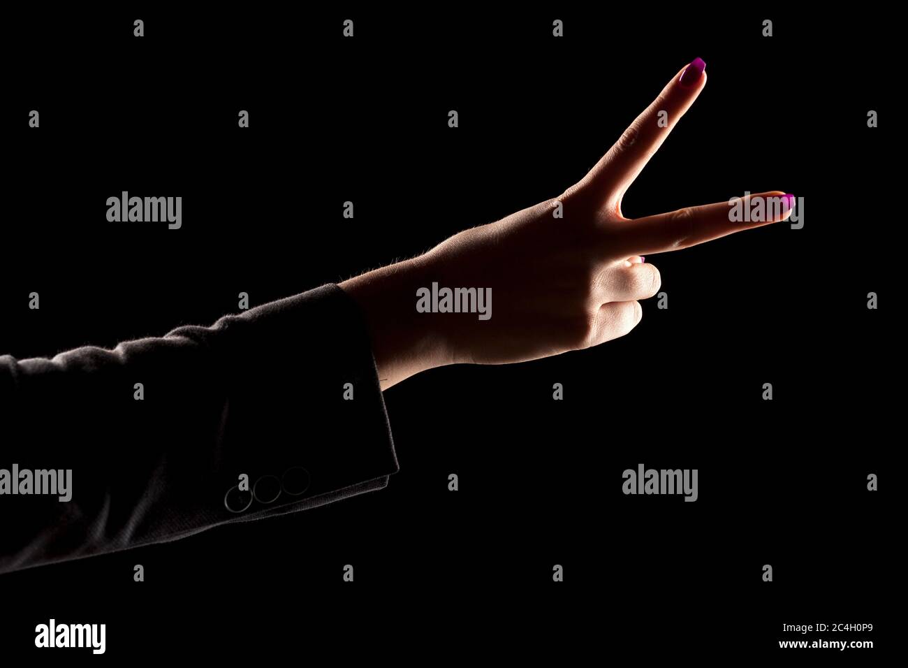 woman's hand on a dark background showing two fingers Stock Photo - Alamy