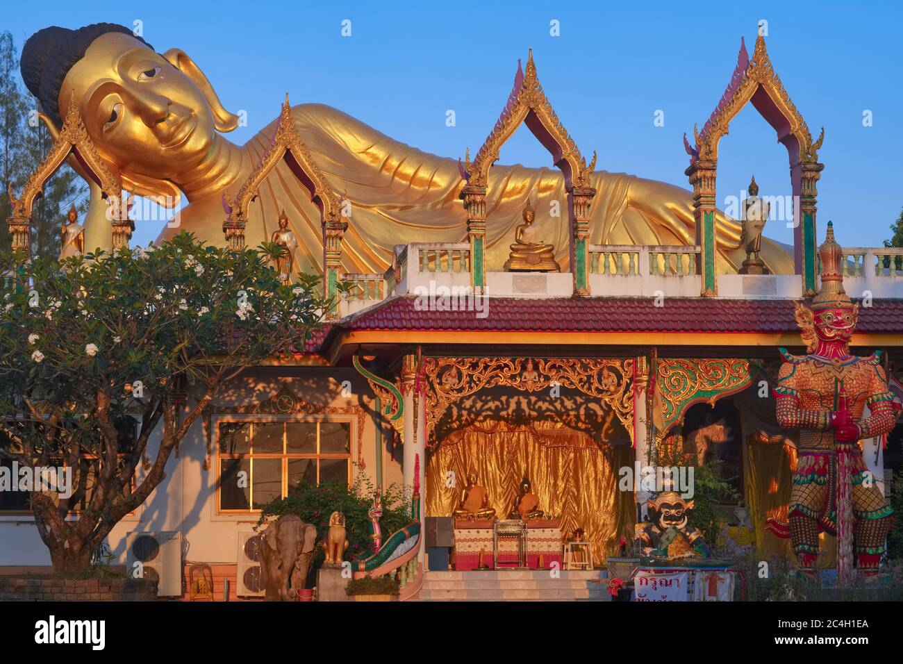 Warm early morning light falls on the 29 m long Reclining Buddha of Wat Sri Sunthorn (Si Sunthon / Wat Lipon), a temple in Thalang, Phuket, Thailand Stock Photo
