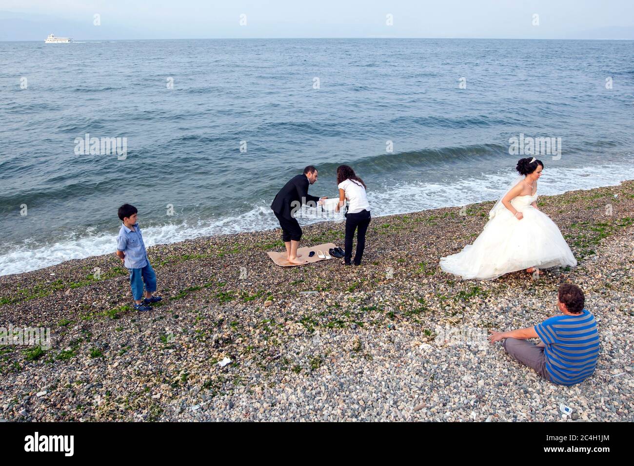 A newly married couple leave the pebble beach at Mudanya in Turkey