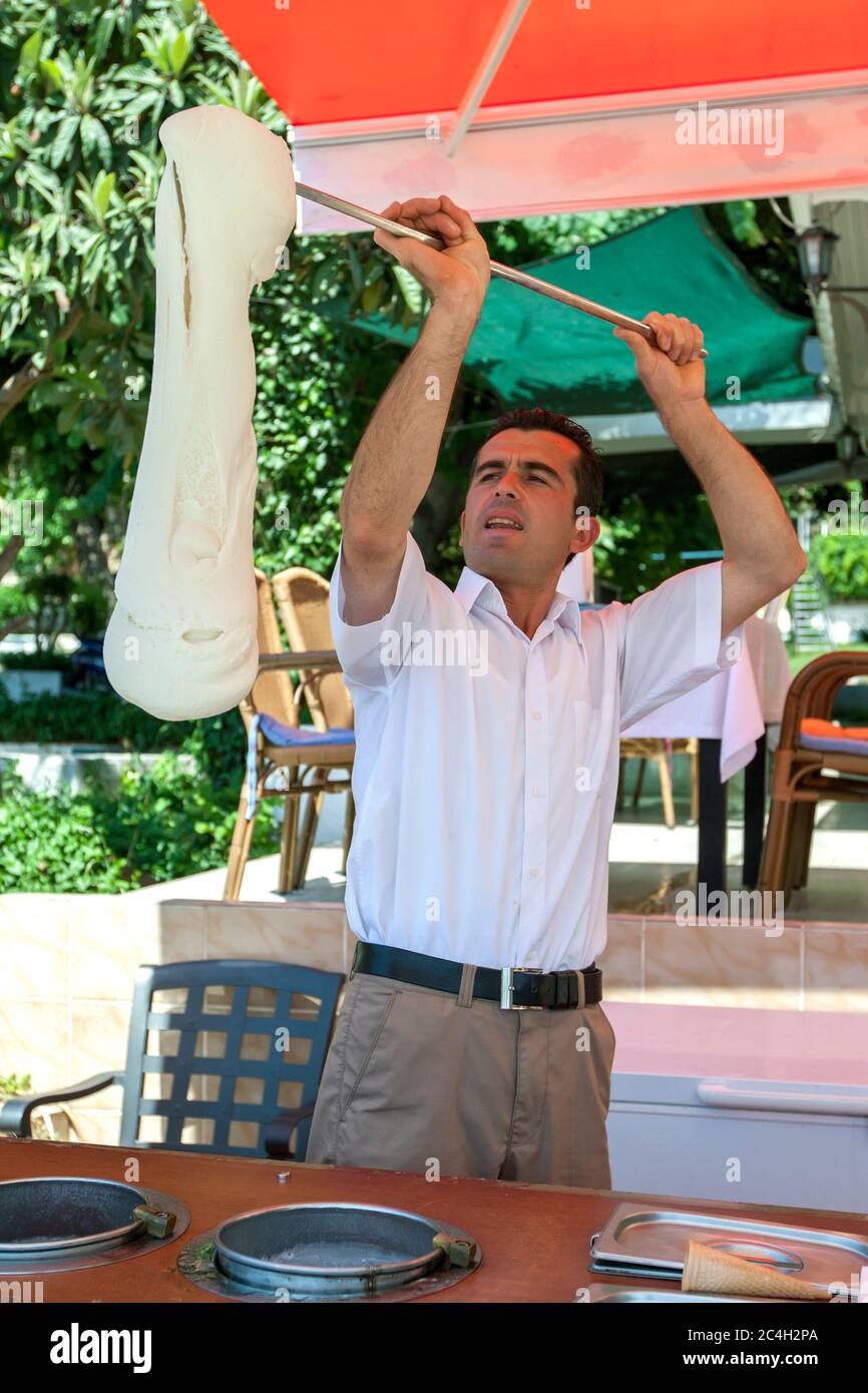 A man twirls Turkish ice cream at his stall at the Roman Harbour in the old town of Kaleici at Antalya in Turkey. Stock Photo