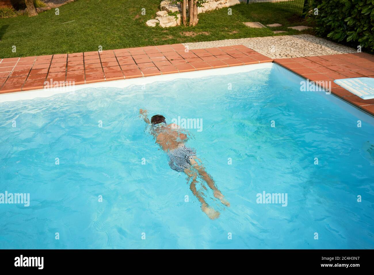Boy swimming in the open pool in summer Stock Photo