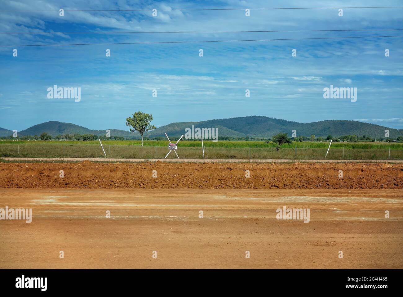 Road construction with the dirt surface having been graded to smooth it out in preparation Stock Photo