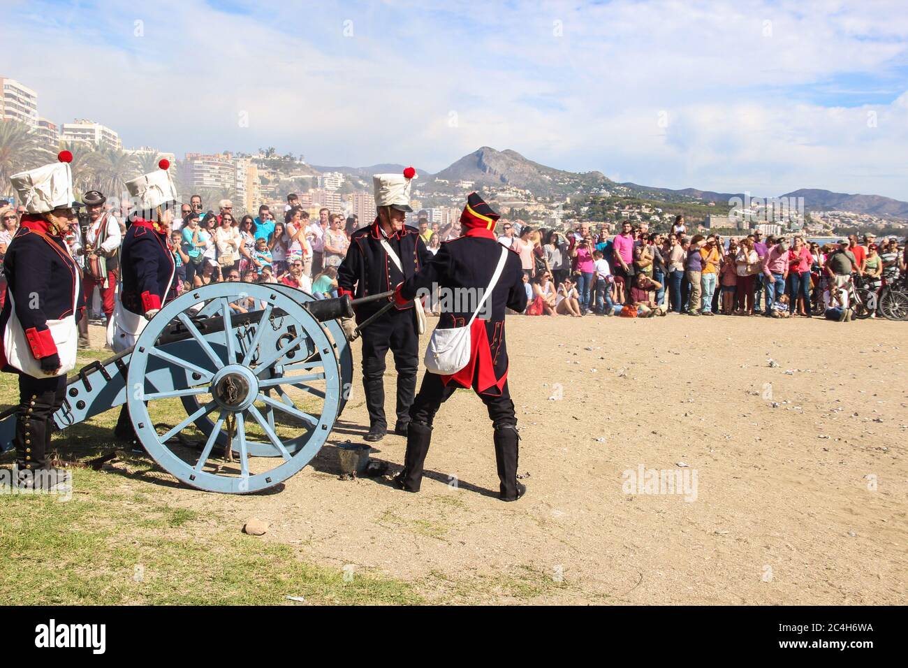 Malaga, Spain - October 26, 2014: 18th century french soldiers loading a cannon with gunpowder. Men and women reenactors. The crowd waits around. Hist Stock Photo