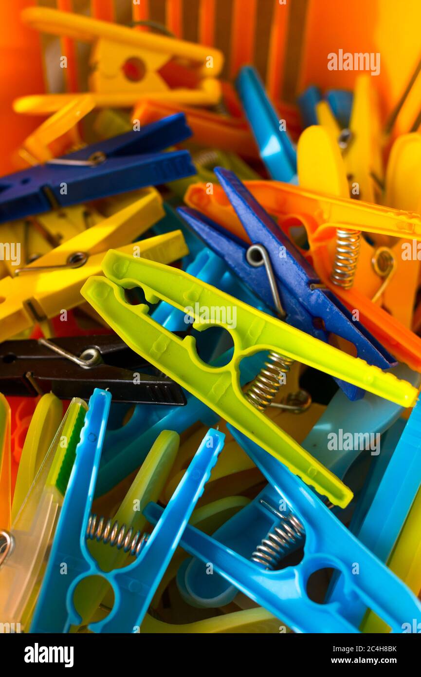 Basket full of colorful plastic clothes pegs. Bright, vivid and colorful image with shallow focus. Stock Photo