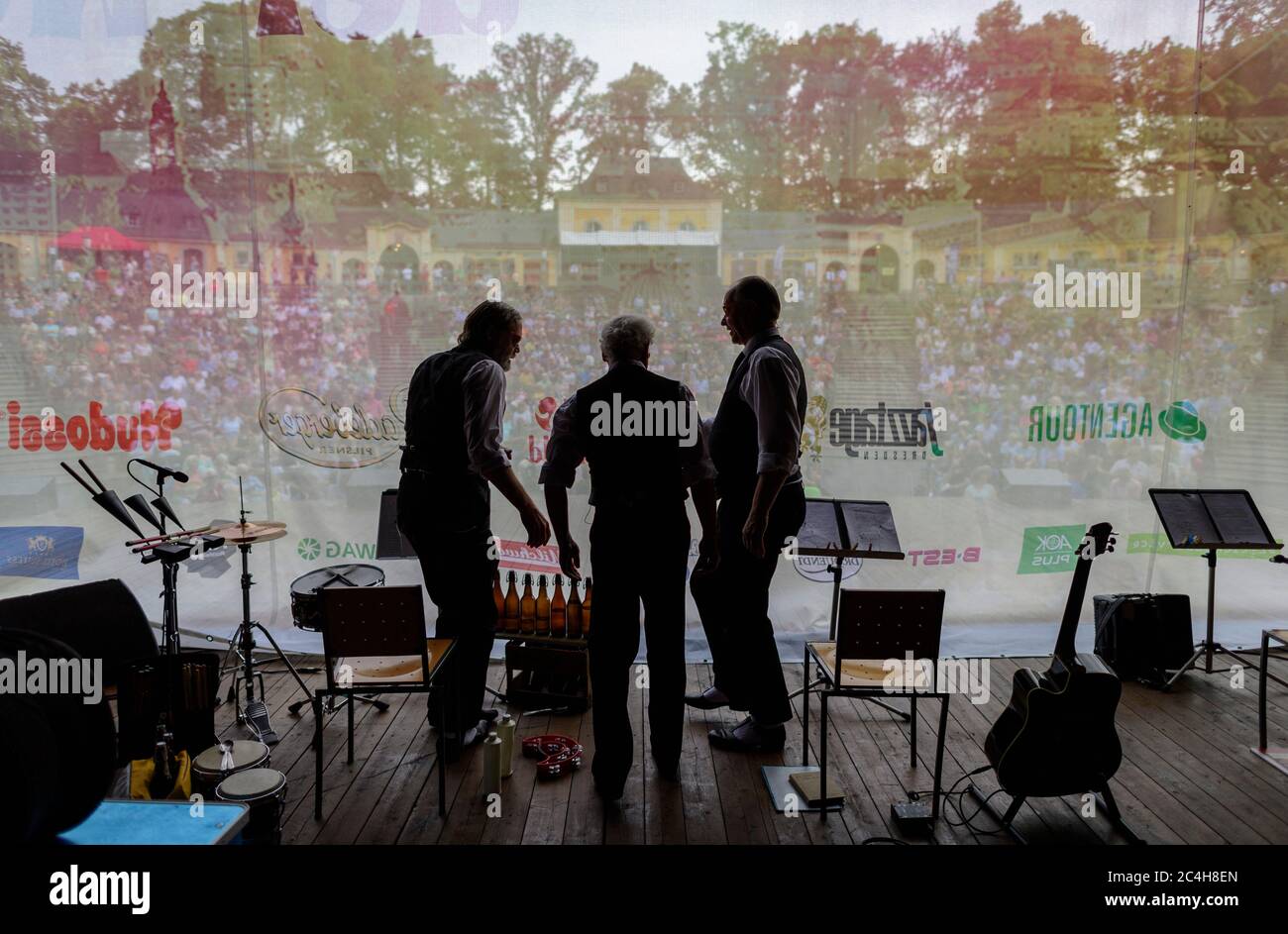 Dresden, Germany. 26th June, 2020. The actors Jürgen Haase (l-r), Tom Pauls and Peter Kube from the cabaret group 'Zwinger Trio' are standing on stage behind the closed curtain before the performance in the open-air theatre Junge Garde in the evening. A team of private theatres, promoters and artists have joined forces and from today on will be staging theatre and concerts in classical amphitheatre architecture under the title 'By far the best open air theatre in the world'. The performances are limited to a maximum of 990 spectators. Credit: Robert Michael/dpa-Zentralbild/dpa/Alamy Live News Stock Photo