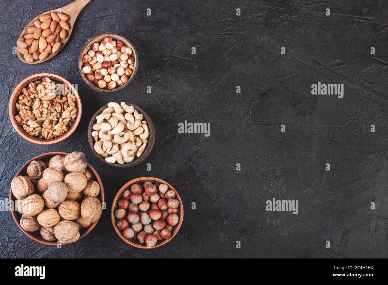 Different nuts in dishes, walnuts, hazelnuts, cashews and almonds Stock Photo