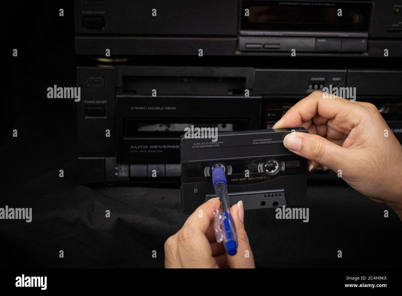 Close up women hand use a pen rewind a cassette tape compact at old