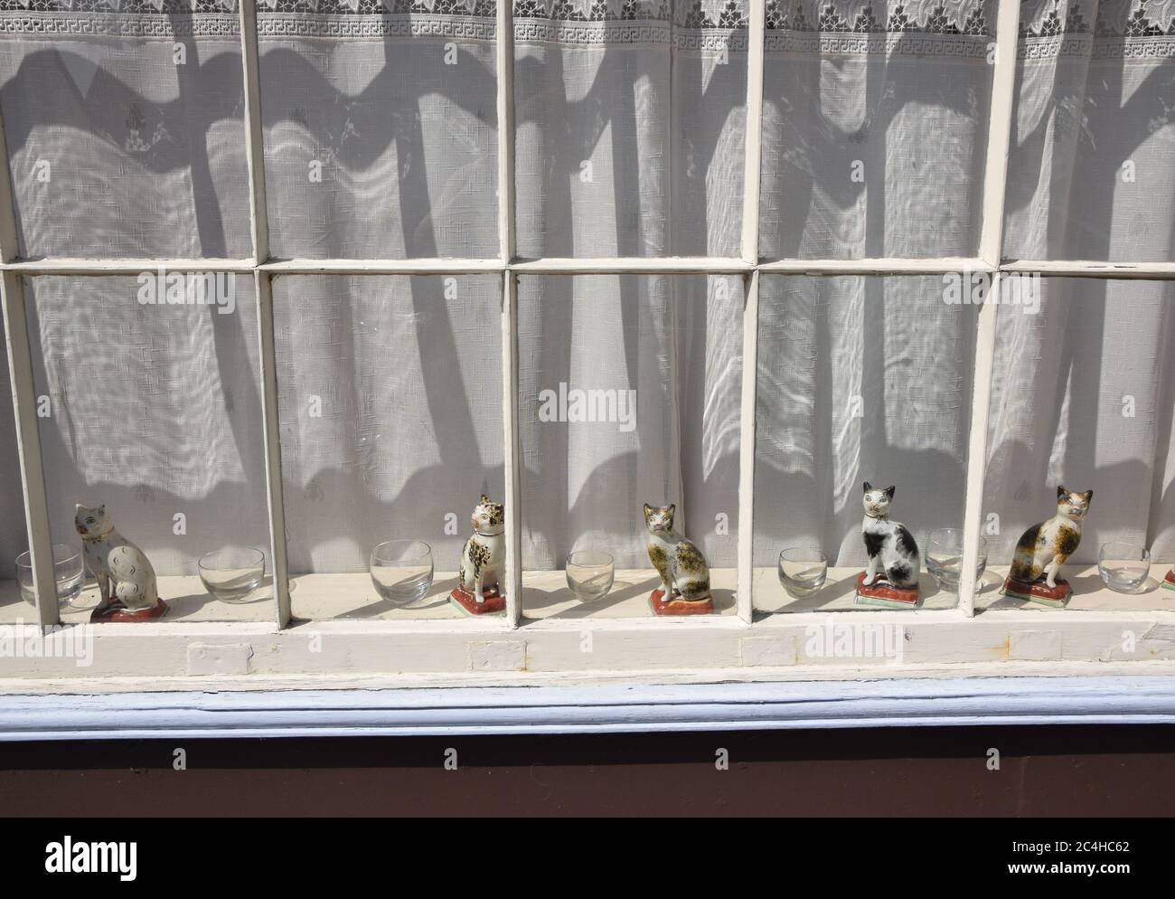 porcelain cat ornaments in window Stock Photo - Alamy