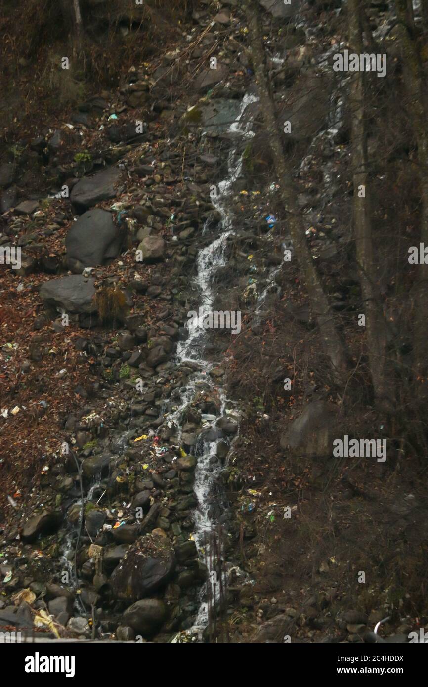 a small waterfall flowing through the rocks. waterfall having rocks and ...