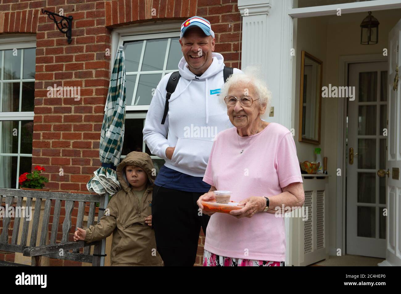 Marlow, Buckinghamshire, UK. 27th June, 2020. Celebrity Chef Tom Kerridge, his furloughed chefs and volunteers from Meals from Marlow have been cooking and delivering free meals to NHS key workers, people self isolating and those in need during the Coronavirus lockdown. Today 75,000th meal was delivered to Joyce aged 90 who lives in Marlow by Tom and his son Acey aged 4 whilst volunteers cheered. Credit: Maureen McLean/Alamy Live News Stock Photo