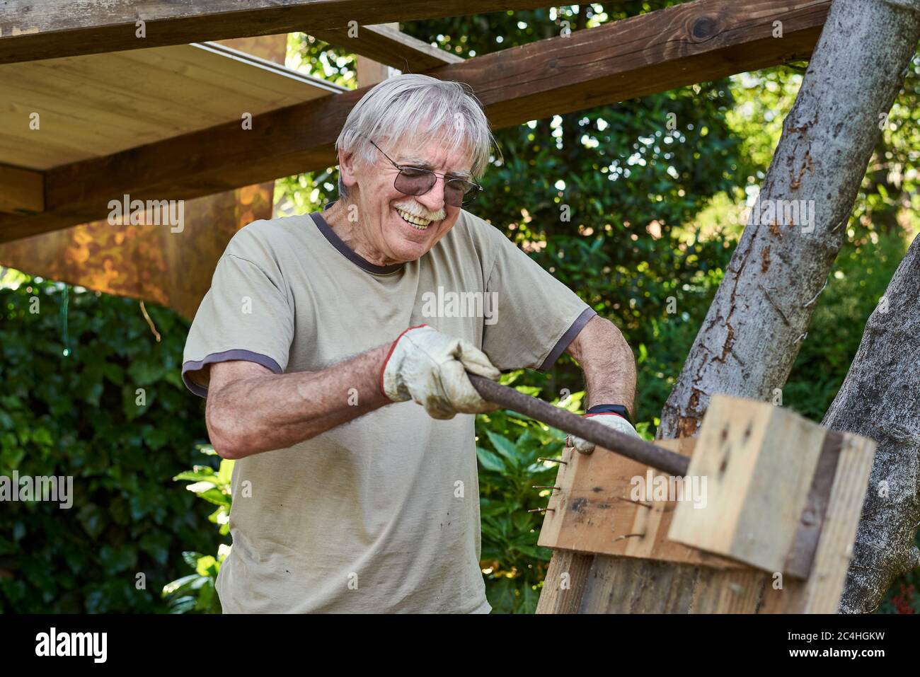 Active senior man in retirement working on the backyard, smiling  Stock Photo