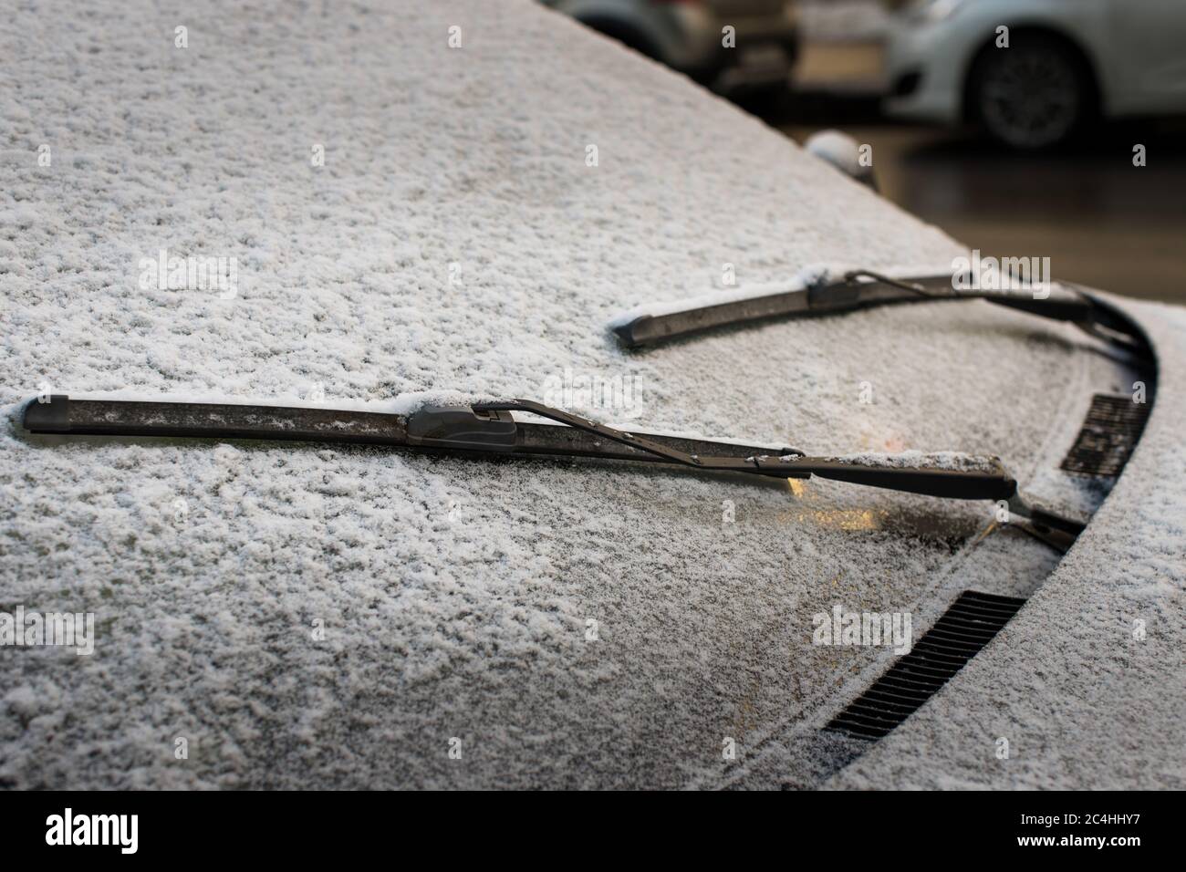 Closeup of wipers and frosted car windshield covered with ice and snow. Winter weather, transportation concept Stock Photo