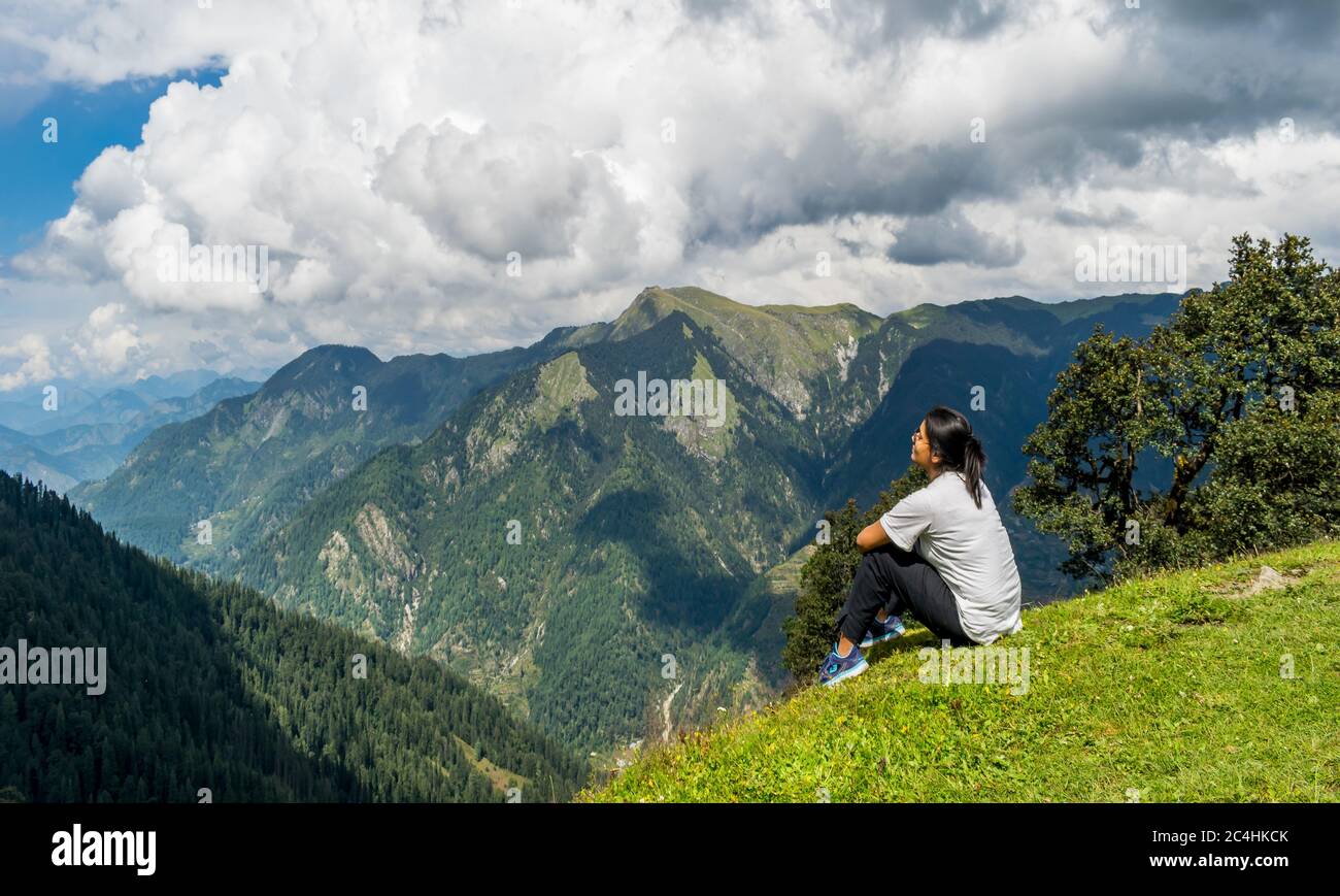 Jalori Pass, Himachal Pradesh, India; 20-September-2019; a solo woman trekker enjoying the mountain view, Jalori Pass, Himachal Pradesh, India Stock Photo
