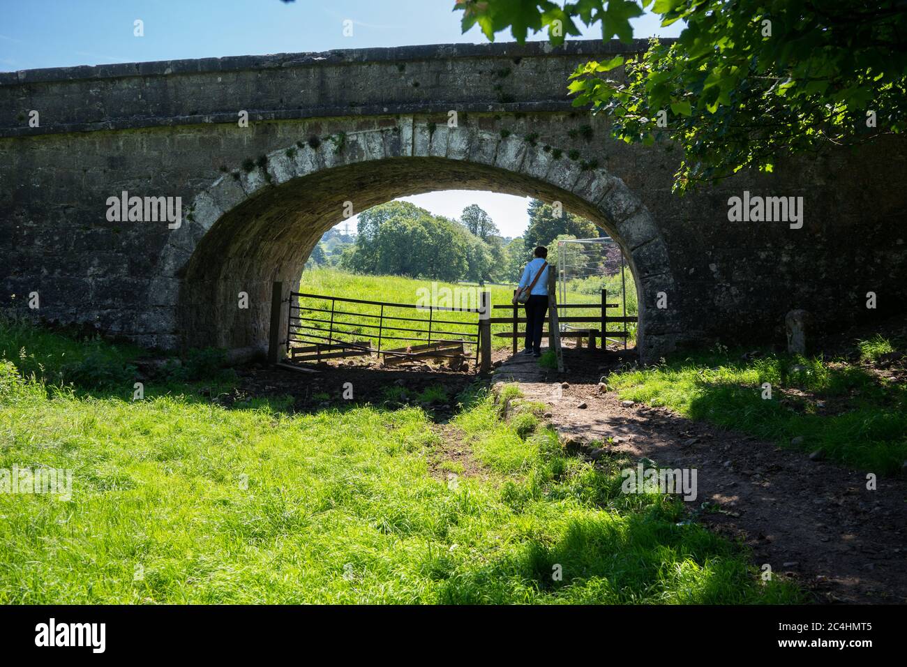 A lone woman walks along the disused Lancaster Canal between Natland and Sedgwick in Cumbria, UK Stock Photo