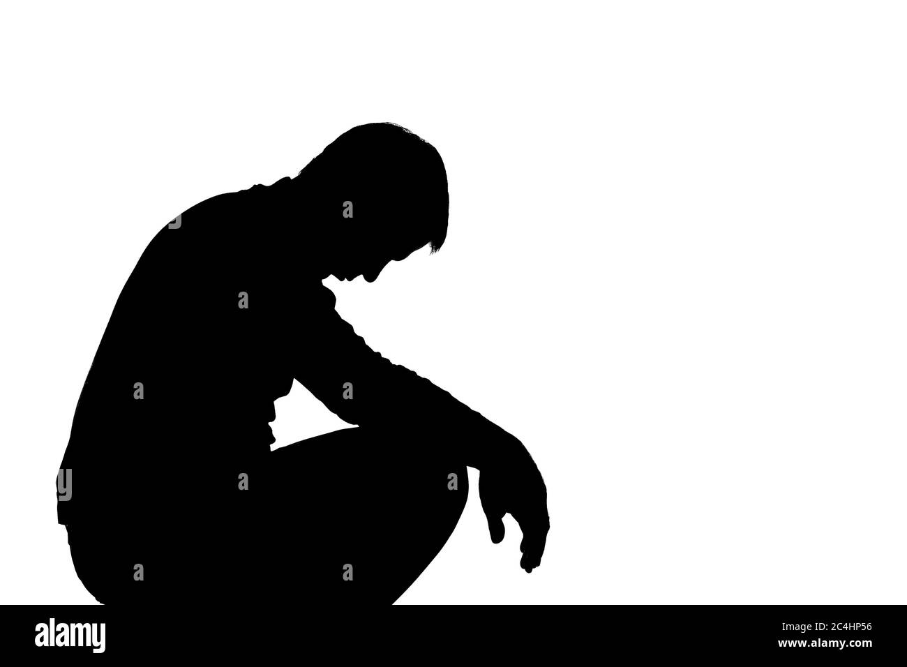 Young man with grief dropped his arms - dark silhouette Stock Photo