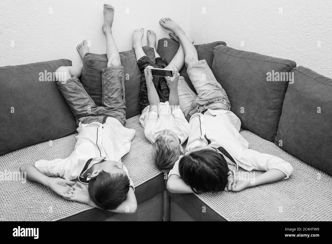 the children sit on the sofa in the room Stock Photo