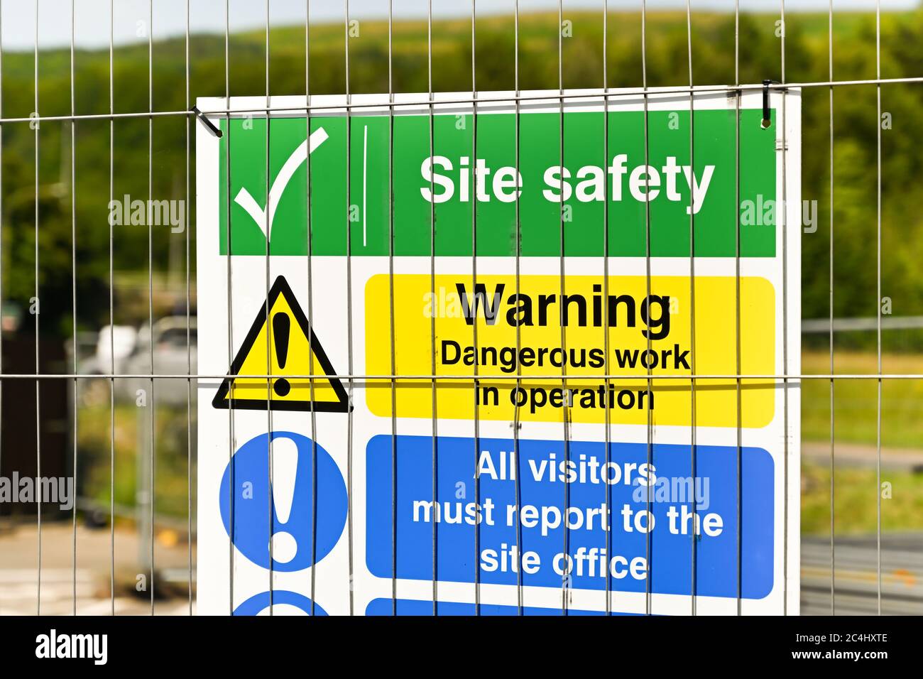 Safety signs on a wire fence around a construction site Stock Photo