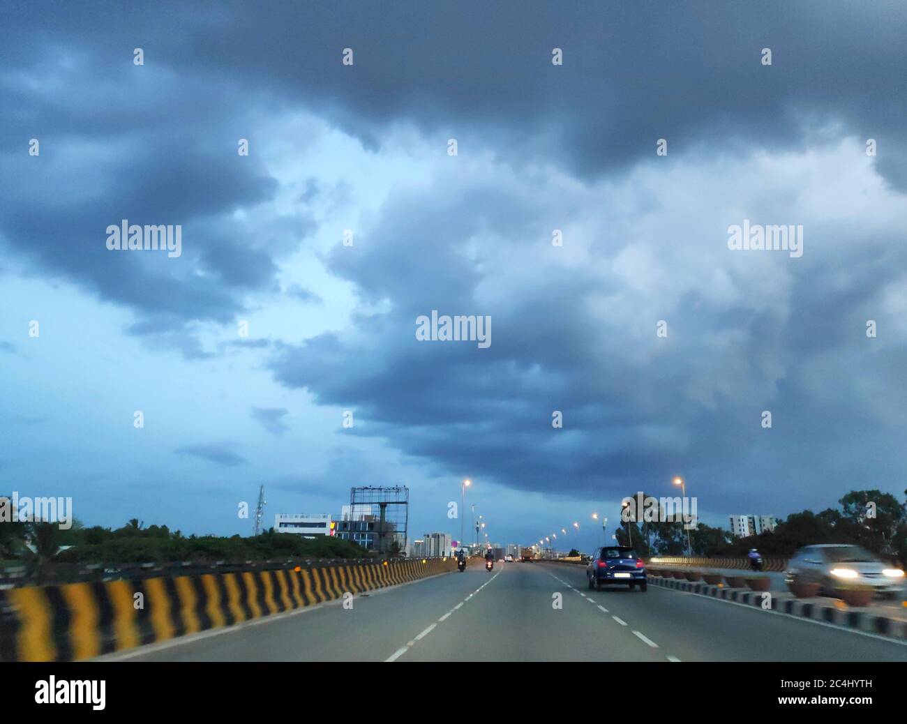 Storm monsoon clouds over a highway at dusk Stock Photo