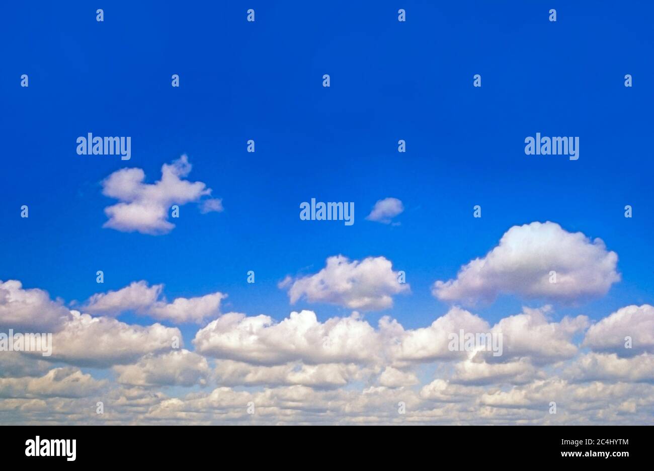 Blue sky, fluffy white clouds, bright sun Stock Photo