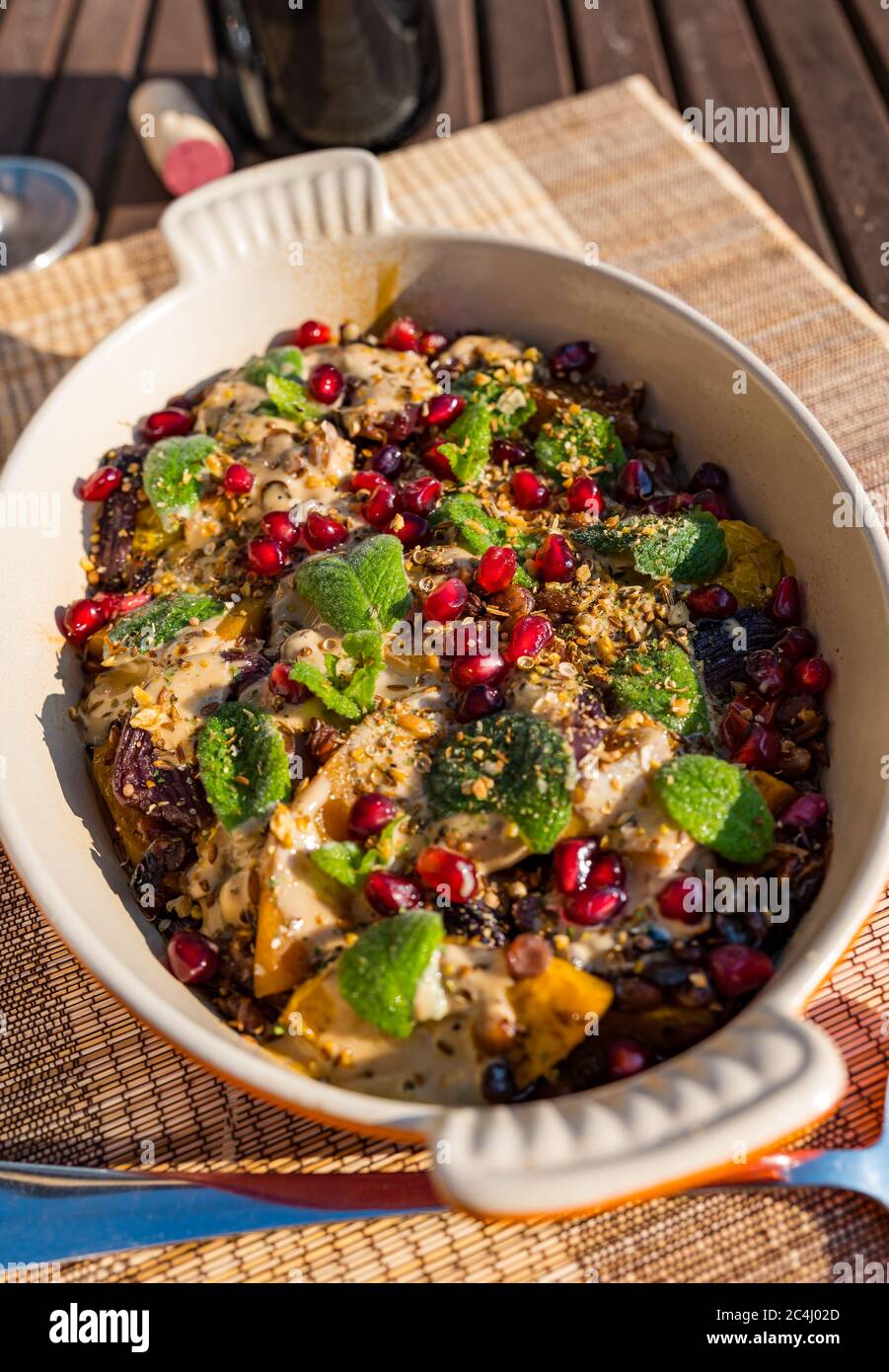 Middle Eastern roasted vegetable dish with lentils, butternut squash and pomegranate seeds, Summer meal outdoors, UK Stock Photo
