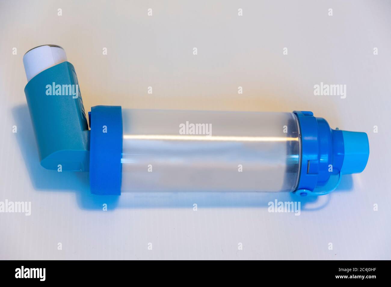 An Asthma reliever inhaler with a spacer ready for use during an attack Stock Photo