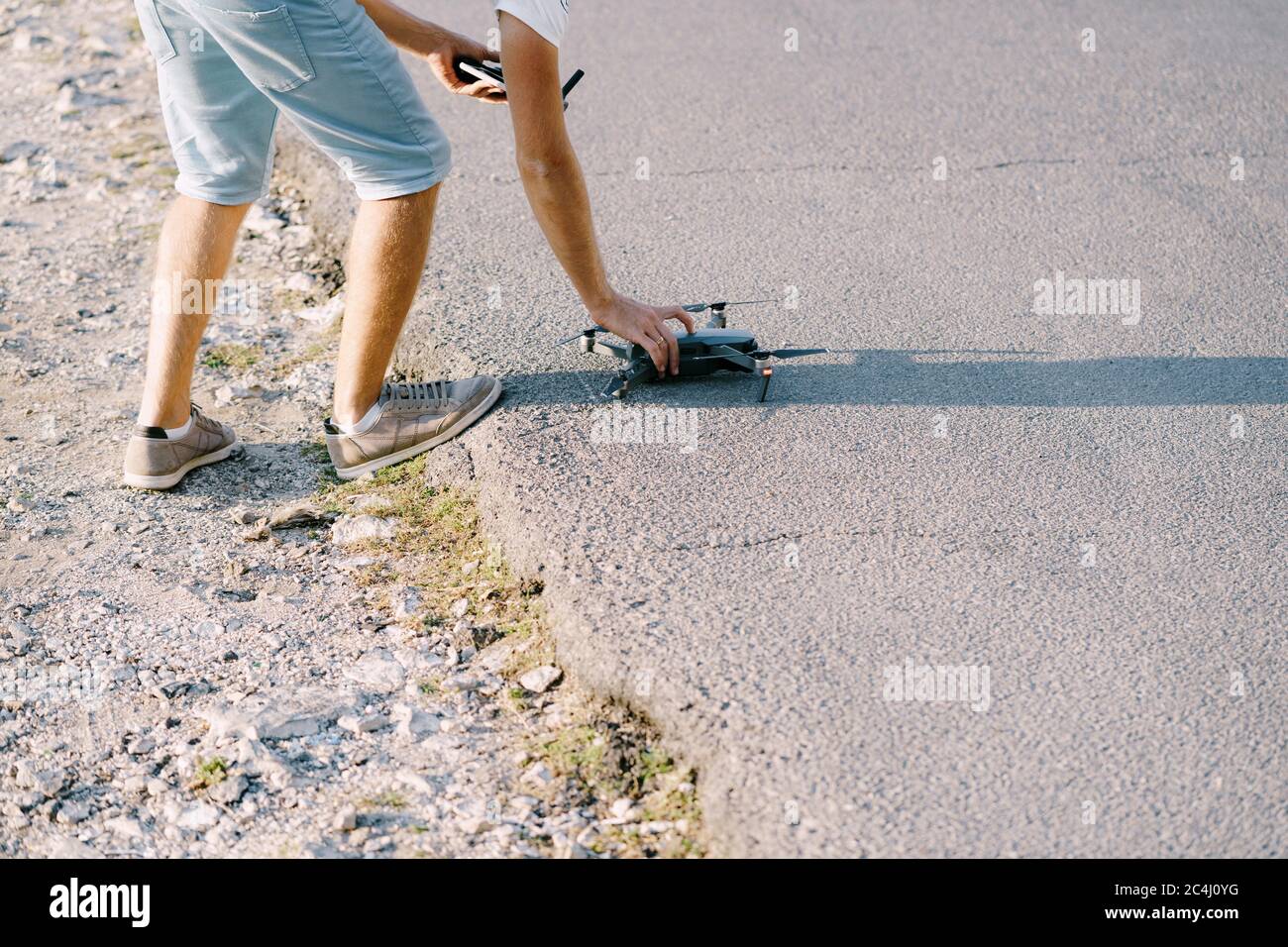 A young guy launches a drone. Preparing the quadcopter for takeoff. Stock Photo