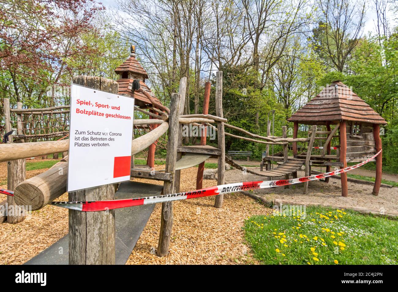 Closed playground with police tape and warning sign (German text: playground closed) due to Corona virus (Covid-19) Stock Photo