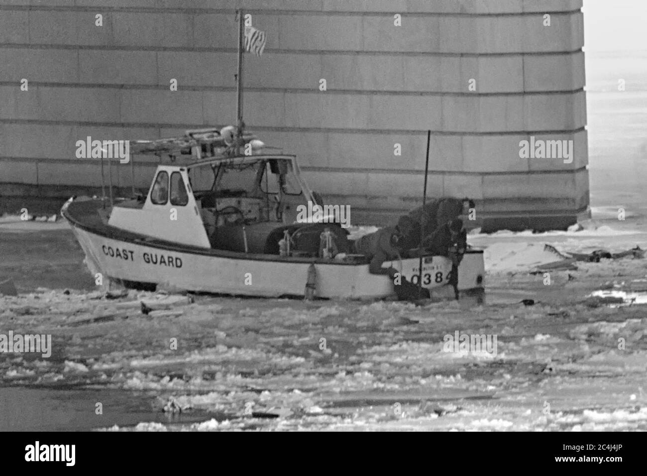 U.S. Coast Guard search and rescue teams recovery the body of a victim of the Air Florida Flight 90 crash from the frozen waters of the Potomac River January 14, 1982 in Washington, D.C. The U.S. domestic passenger flight crashed into the river after colliding with the 14th Street Bridge on January 13, 1982 killing 74 people. Stock Photo