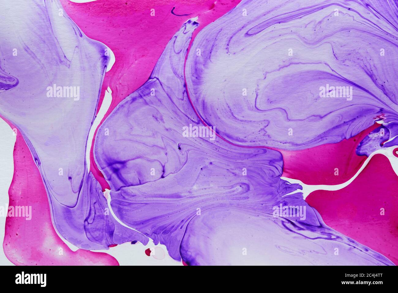 Abstract fluid marbleized effect or background pattern with free flowing swirls of purple and magenta on white in full frame Stock Photo