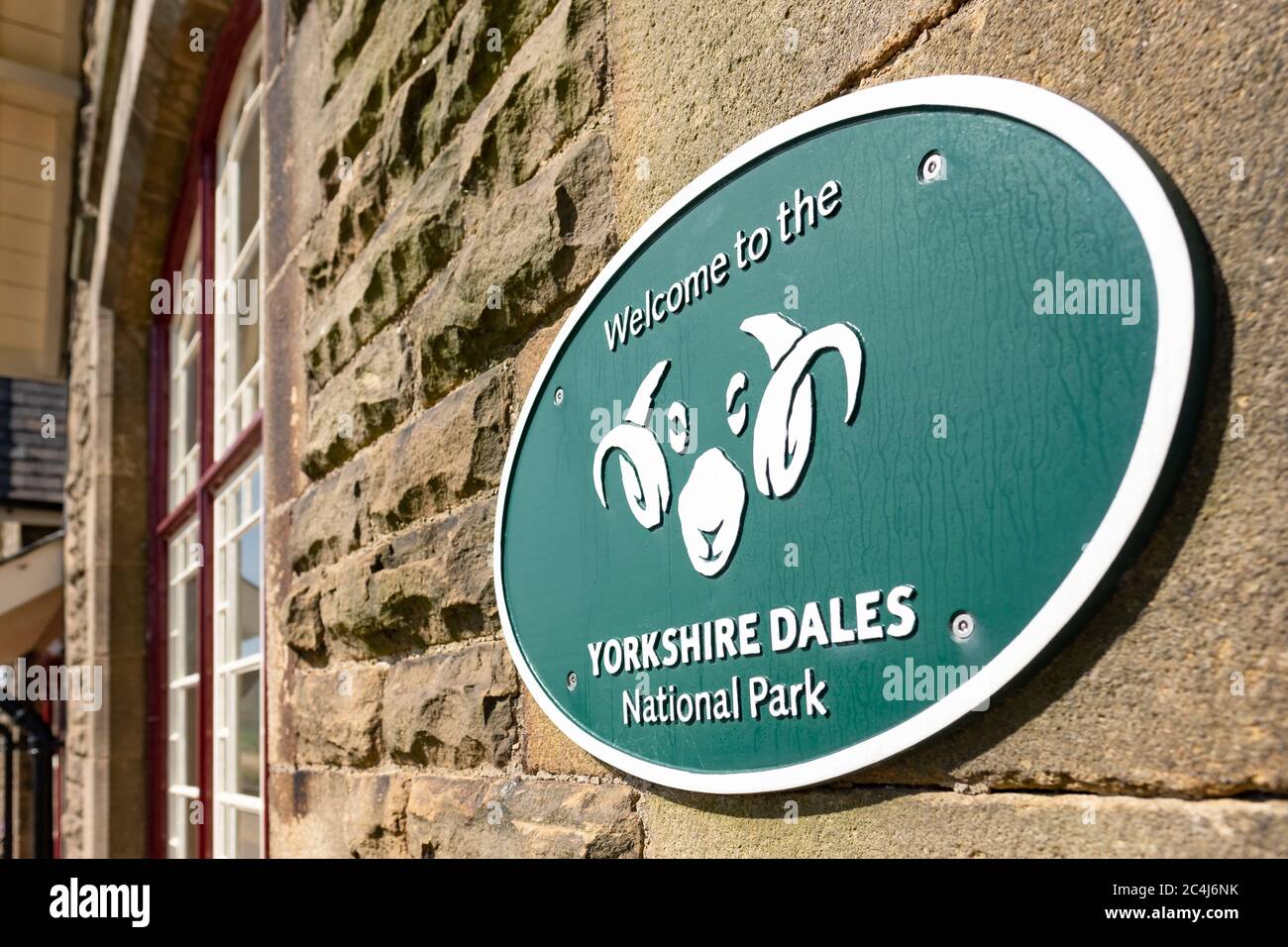 Detailed view of a well-known UK national park metal sign seen attached to a small, historic railway station waiting room wall. Stock Photo