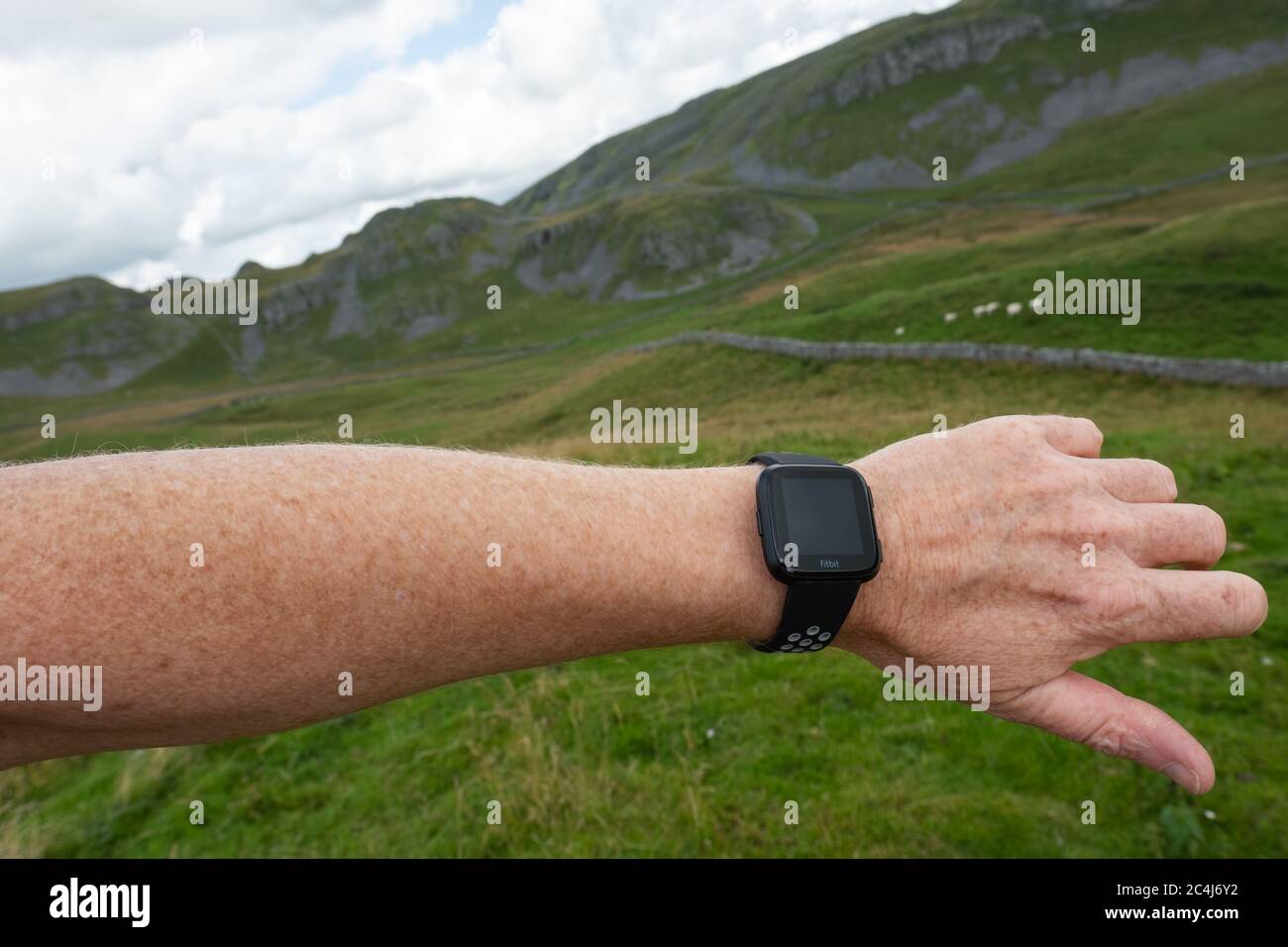 Adult male seen wearing a popular fitness tracker on his left wrist