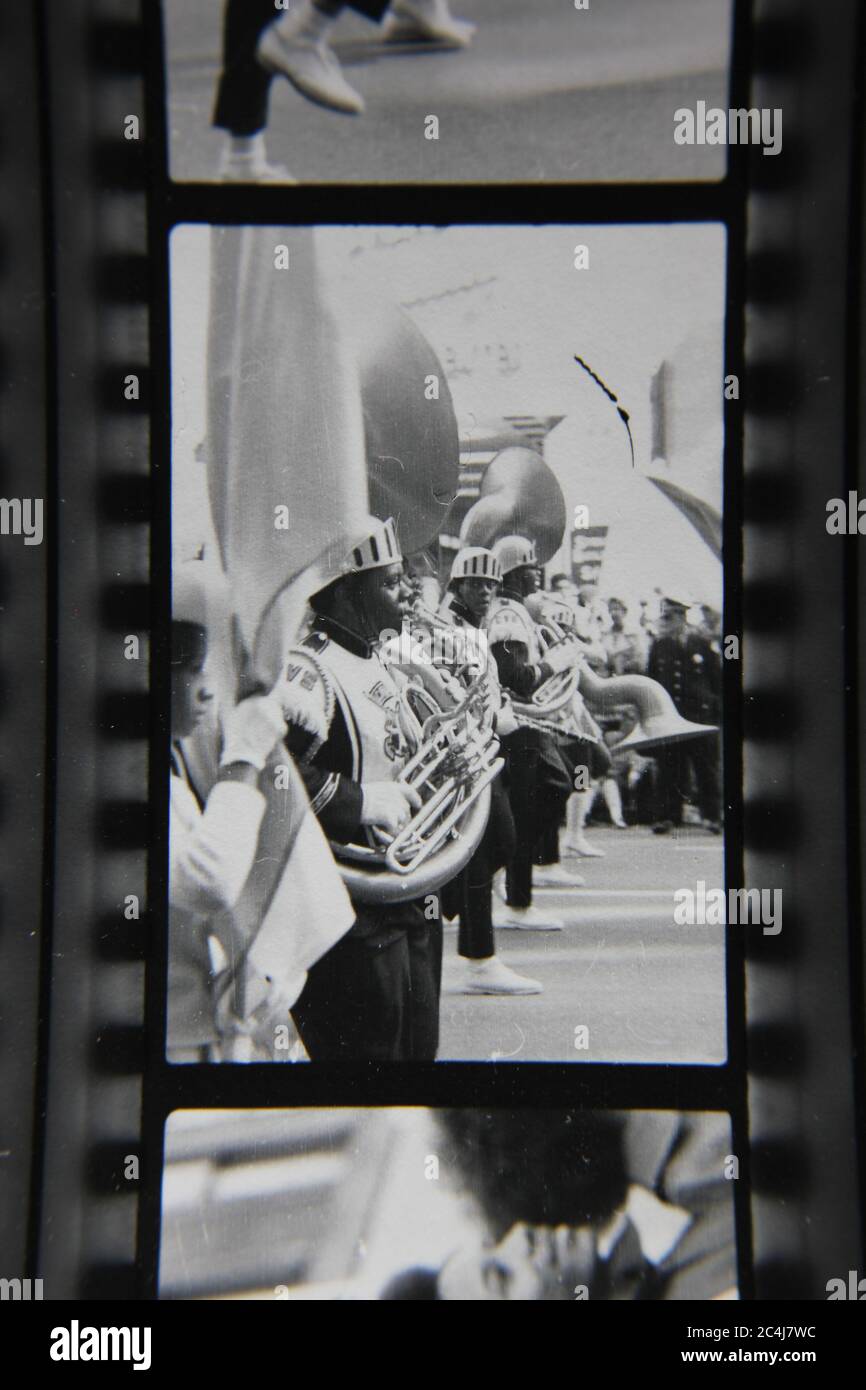 Fine 70s vintage contact print black and white photography of a high school student playing the tuba in a marching band in a downtown Chicago parade. Stock Photo