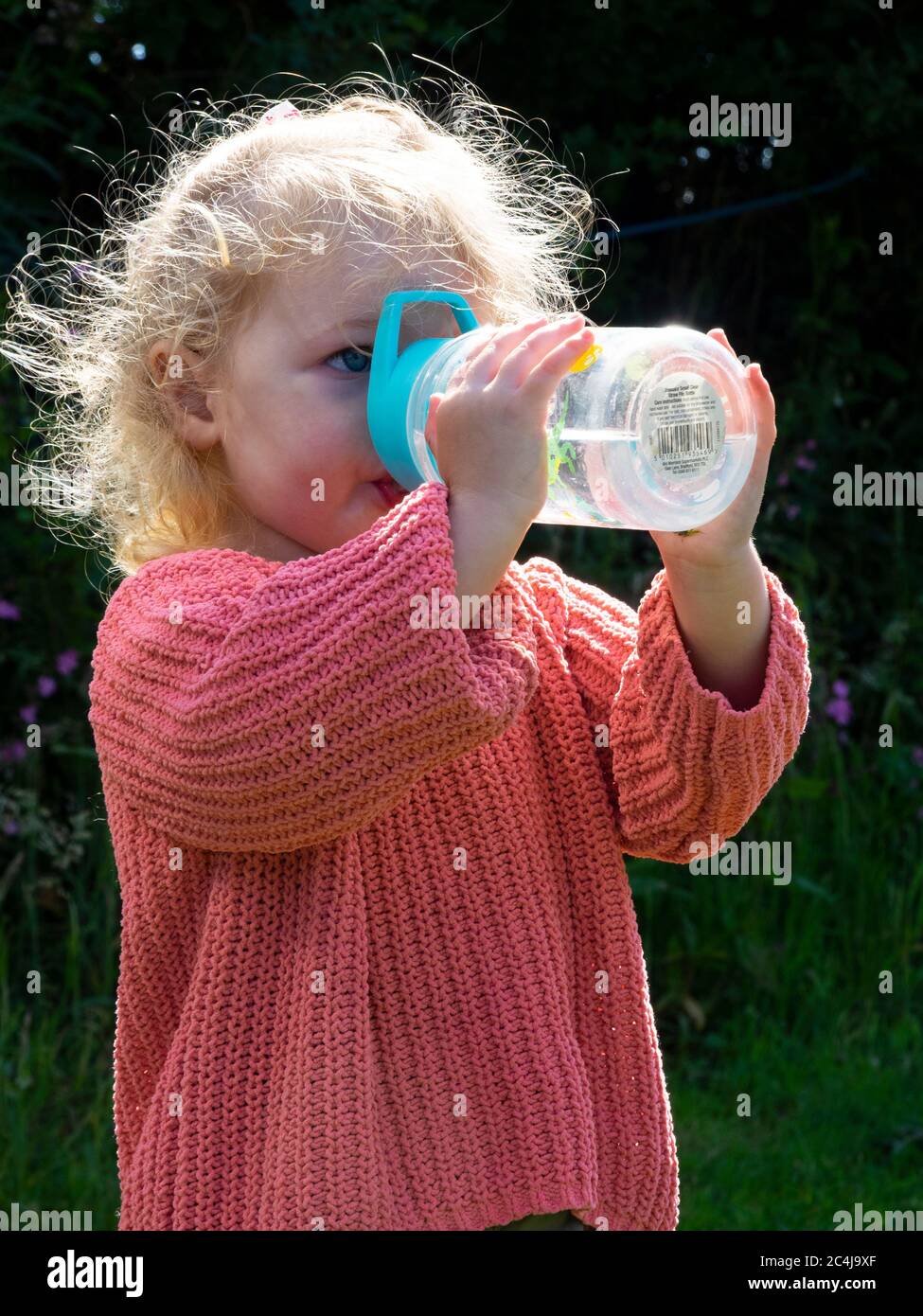 Toddler drinking from a soft straw spout water bottle, UK Stock Photo
