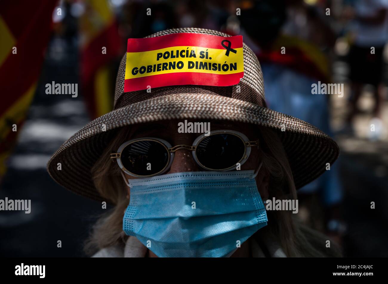 Madrid, Spain. 27th June, 2020. A woman is seen with a sticker with the words: 'Yes to police. Government resignation', during a protest to demand the resignation of Prime Minister Pedro Sanchez and to protest against the government's management of the health crisis due to the coronavirus (COVID-19) outbreak. Credit: Marcos del Mazo/Alamy Live News Stock Photo