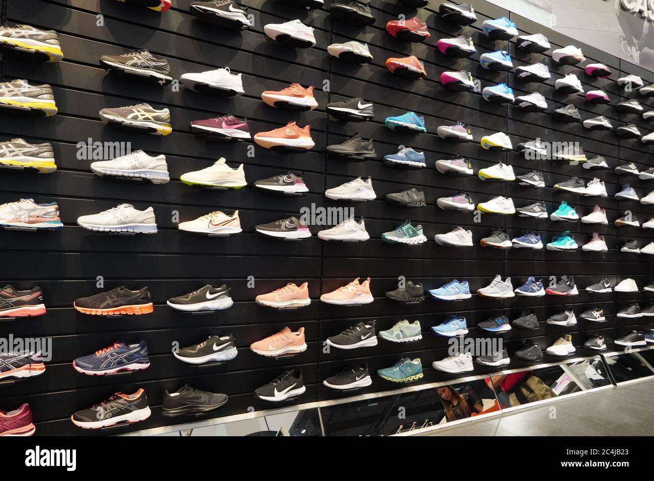 Shop display of a lot of Sports shoes on a wall. A view of a wall