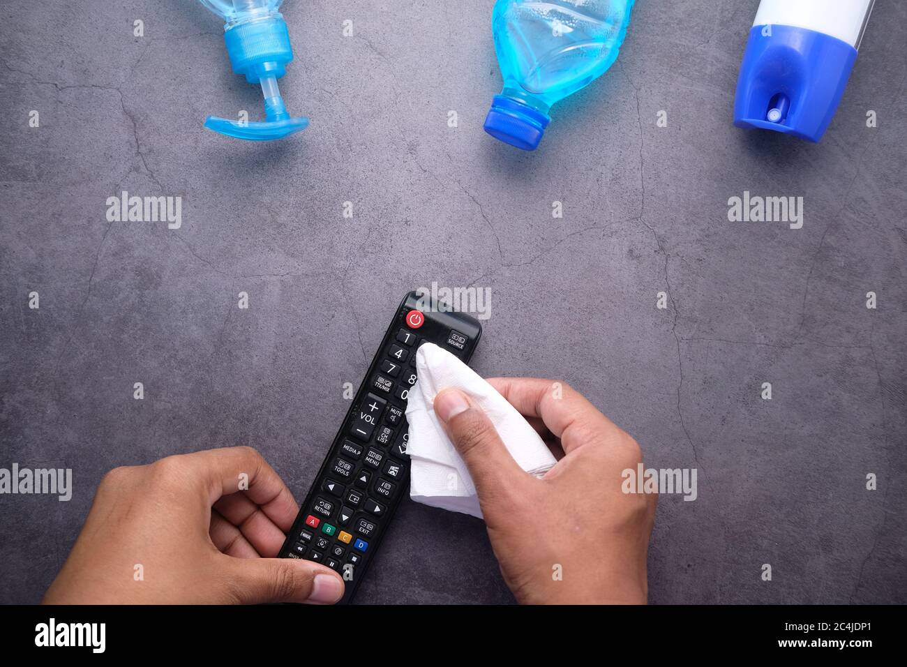 man hand cleaning TV remote controller with disinfectant wet wipe Stock