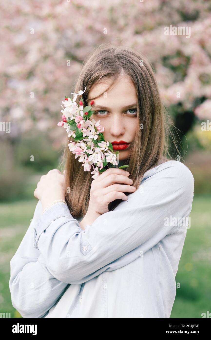Portrait of a young woman holding spring flowers Stock Photo - Alamy