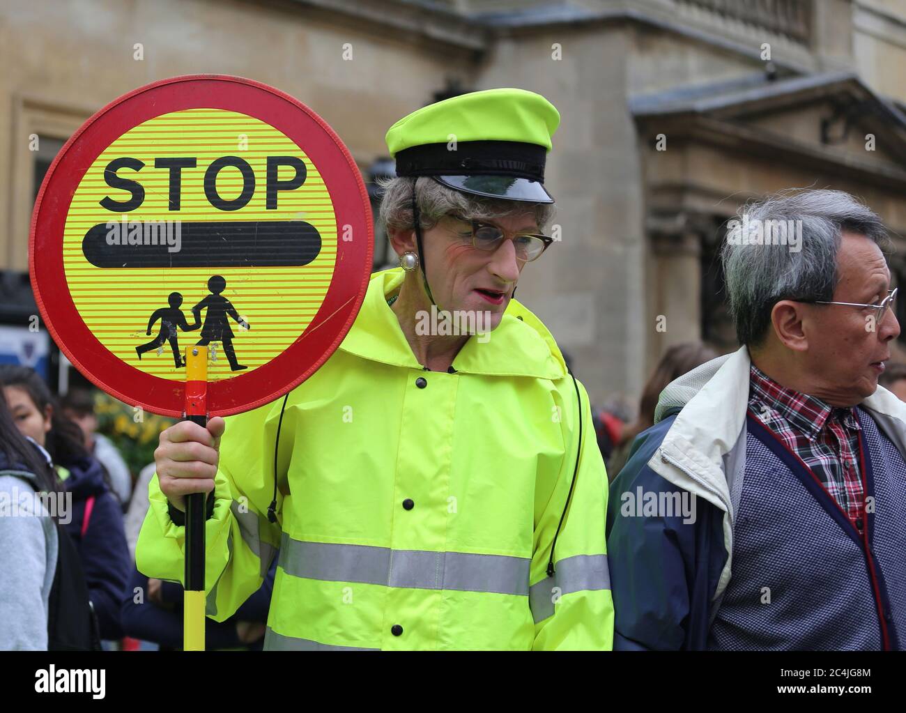 Lollipop lady halting traffic in front of the Pump Room in the city center of Bath,Somerset,England,United Kingdom.15th of July,2017. Stock Photo
