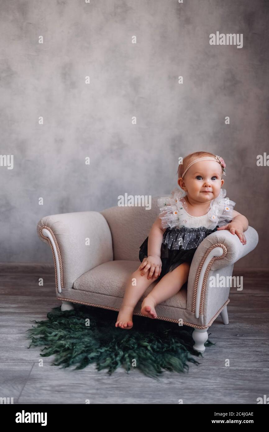 Cute newborn baby on sofa. Infant girl sitting on special little baby  furniture Stock Photo - Alamy