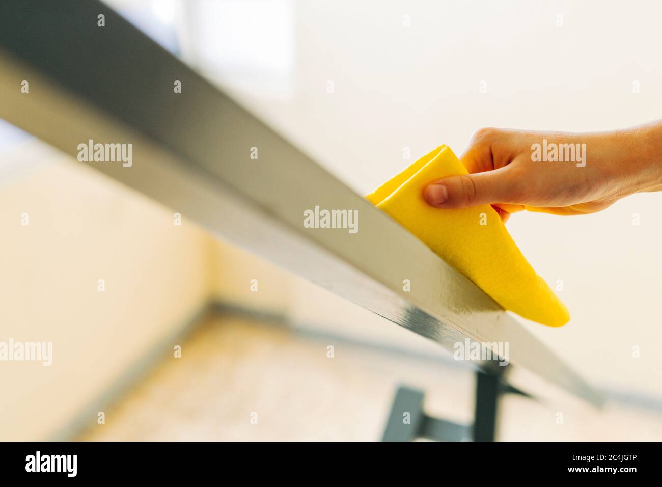 Cleaner wiping a railing with a cloth. Cleaning and disinfection