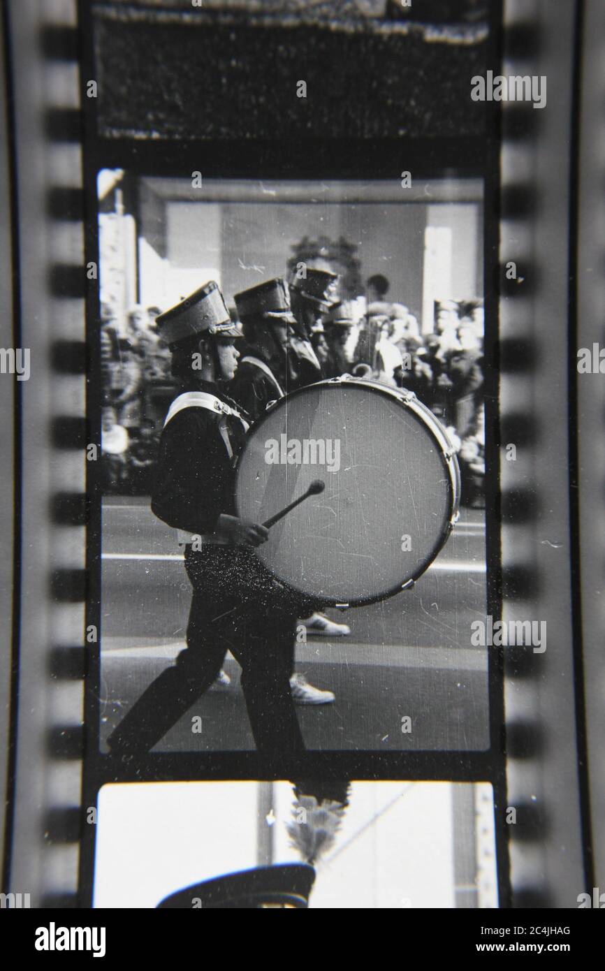 Fine 70s vintage contact print black and white photography of a high school marching band marching thru a downtown Chicago parade. Stock Photo