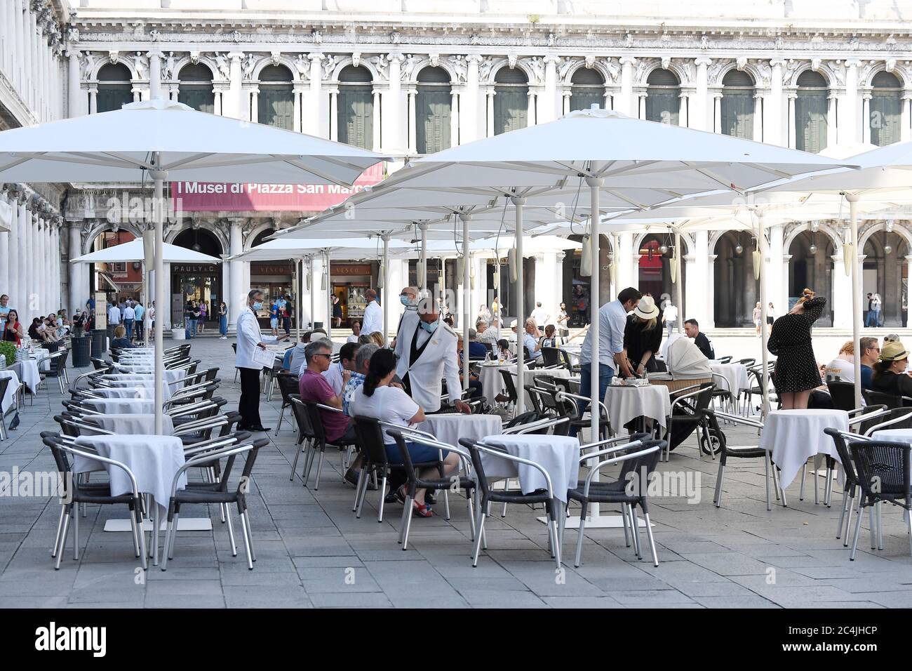 06/27/2020 Venice: umbrellas in Piazza San Marco to guarantee the distance Anti-crisis move of historic cafes. The managers assure: they will be the least impactful. But there is no lack of controversy. In San Marco square in Venice the first umbrellas were mounted that will cover the spaces in front of the premises, enlarged to facilitate the safe arrangement of the tables according to the safety rules on coronavirus. The first covers were set up in front of the Caffè Florian. Then the workers' teams moved on to Quadri, Lavena and will conclude at the Aurora and Chioggia cafes, in front of Pa Stock Photo