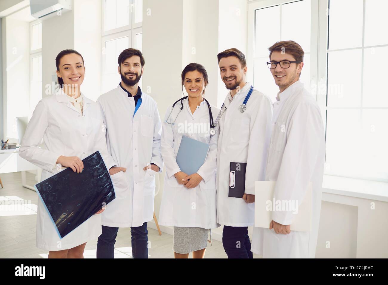Group of young doctors standing together at hospital hall. Team of