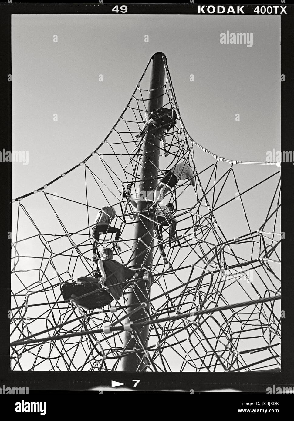 Kids climbing a tower made of rope on a park playground. Riverview Park, Mesa, Arizona.  March 21, 2020. Image from 6x4.5 cm negative. Stock Photo
